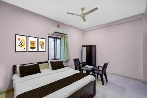 a bedroom with a bed and a table with chairs at Hotel O Candel Light Inn in Bhubaneshwar