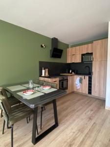 a kitchen and dining room with a table and chairs at Appartement Plein Soleil in Les Rousses