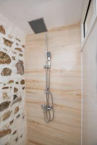 a shower in a bathroom with a stone wall at Villa Sofia in Evkarpía +36 photos