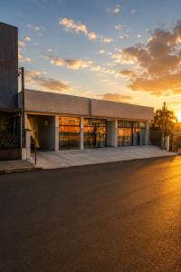 an office building with a sunset in the background at Sely Suítes in Ametista do Sul