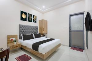 a bedroom with a large bed and a window at Super HOTEL O MATRI CROWN in Raipur
