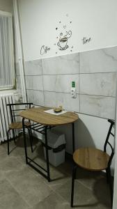 a table and chairs with a coffee sign on a wall at Apartman Pavlov 023 in Zrenjanin