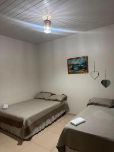 a bedroom with two beds and a blue light on the ceiling at Solar DorisMar in Luis Correia +25 photos