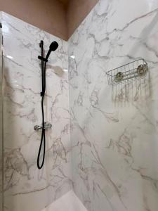 a bathroom with a shower with a white marble wall at Spacious T4 Central Apartment with Iconic Tram 28 View in Lisbon +81 photos