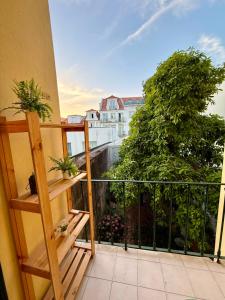 a balcony with potted plants and a view of a city at Spacious T4 Central Apartment with Iconic Tram 28 View in Lisbon