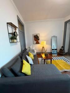 a living room with a gray couch and yellow pillows at Spacious T4 Central Apartment with Iconic Tram 28 View in Lisbon