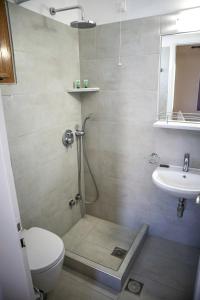 a bathroom with a shower and a toilet and a sink at The Windmill in Ios Chora