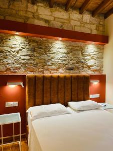 a bedroom with a bed and a stone wall at Kalavasos Xenia in Kalavasos