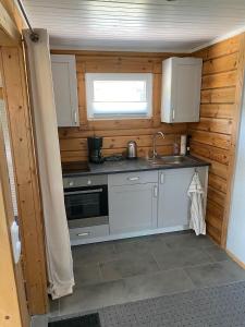 a kitchen with white cabinets and a sink and a window at Haus der Sinne in Buddenhagen +6 photos