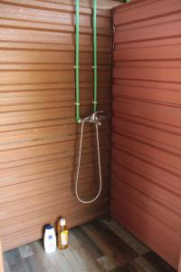 a shower in a wooden wall with green pipes at Camp River Skadar Lake in Gostilj