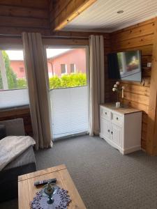a living room with a television and a couch and a table at Haus der Sinne in Buddenhagen