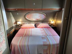 a small bedroom with a bed and a window at Caravan with private toilet and kitchen 2 in Grebaštica