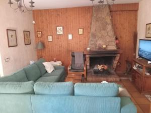 a living room with a blue couch and a fireplace at La Cárcava in La Serna del Monte