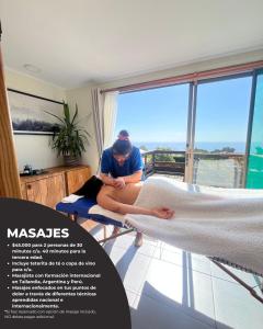 a woman sitting on a bed in a room with a window at Viento Sur Pichilemu Lodges Cama King con Calientacamas in Pichilemu