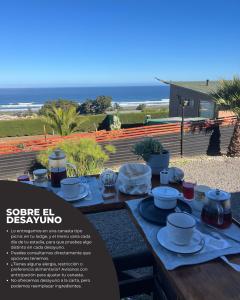 a table with food on it with the ocean in the background at Viento Sur Pichilemu Lodges Cama King con Calientacamas in Pichilemu +13 photos