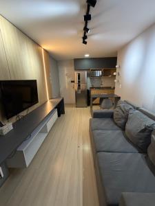 a living room with a couch and a flat screen tv at Apartamento no Edifício Manhattan - Bairro Nobre de Caruaru in Caruaru