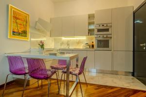a kitchen with a table and purple chairs at SOPRA il MARE con KATE in Genoa