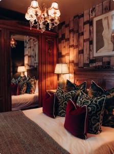 a bedroom with a bed with pillows and a mirror at The Roebuck Inn in Mobberley