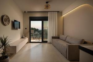 a living room with a couch and a sliding glass door at Pnoe Boutique suites in Nikiti