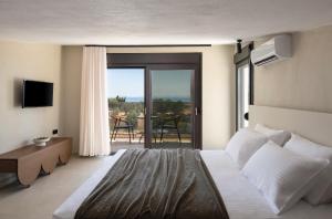 a bedroom with a bed and a view of a patio at Pnoe Boutique suites in Nikiti +46 photos
