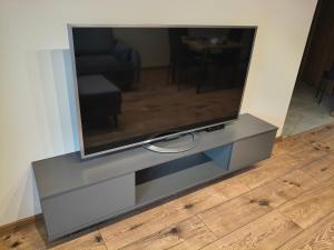 a flat screen tv sitting on a entertainment center at Apartament Matki Polki II in Łódź