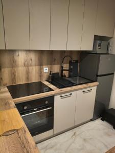 a kitchen with white cabinets and a stove top oven at Apartament Matki Polki II in Łódź