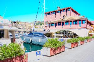 a boat is docked next to a pink building at SOPRA il MARE con KATE in Genoa