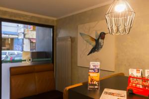 un pájaro en la pared de un restaurante con una lámpara de araña en Hotel West, en Hamburgo