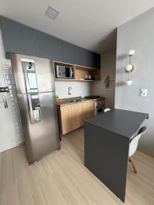 a kitchen with a stainless steel refrigerator and a table at Apartamento no Edifício Manhattan - Bairro Nobre de Caruaru in Caruaru