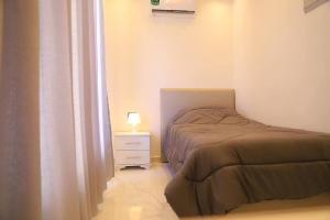a bedroom with a bed and a night stand with a lamp at Bader home in Cairo