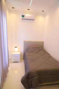 a small bedroom with a bed and a night stand at Bader home in Cairo
