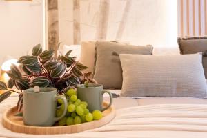 a tray with cups and grapes on a couch at Luxury Garden Suite with Private Heated jacuzzi in Perugia