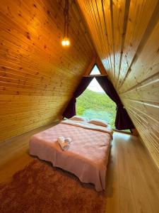 a bed in a wooden room with a window at Mtis qokhi Twins in Mtskheta