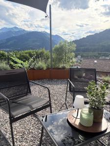 a patio with two chairs and a table with a view of mountains at Everest Experience in Paluzza
