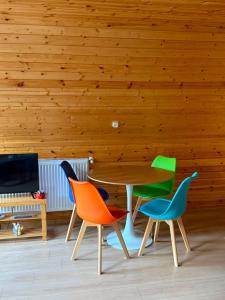 a table and chairs in a room with wooden walls at Mtis qokhi Twins in Mtskheta