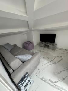 a living room with a couch and a flat screen tv at Mansarda al mare in Tortoreto Lido