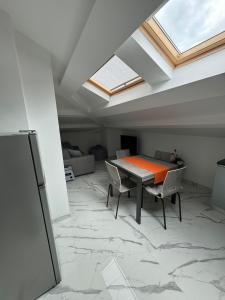 a dining room with a table and chairs and a skylight at Mansarda al mare in Tortoreto Lido
