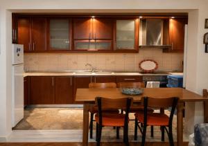 a kitchen with wooden cabinets and a table and chairs at Kolhida home in Kilkis