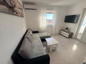 a living room with a couch and a table at Apartmani Lucija 3 in Zubovići