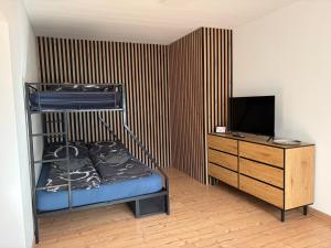 a bedroom with a bunk bed and a dresser with a television at Patrycja 2 Top 1 in Ehenbichl