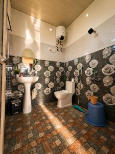 a bathroom with a toilet and a sink at Doi Stays Dak Bungalow in Almora