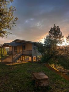 a house with a bench in the yard at Doi Stays Dak Bungalow in Almora