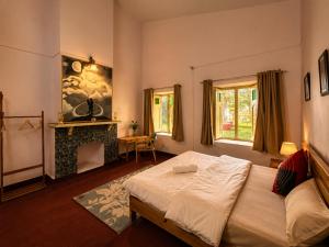 a bedroom with a large bed and a fireplace at Doi Stays Dak Bungalow in Almora