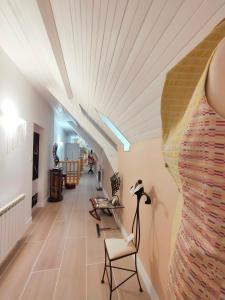 a hallway with a table and a dress on the wall at Morphoses, Maison de créatrice & parc privé près de Chenonceaux in Chissay-en-Touraine