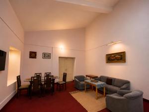 a living room with a couch and a table and chairs at Doi Stays Dak Bungalow in Almora