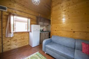 a living room with a couch and a refrigerator at Kozalak Bungalows in Çaykenarı