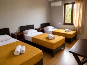 a hotel room with three beds with towels on them at Hotel Kopala Ureki in Ureki