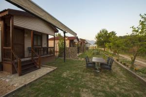 a patio with a table and chairs next to a house at Kozalak Bungalows in Çaykenarı