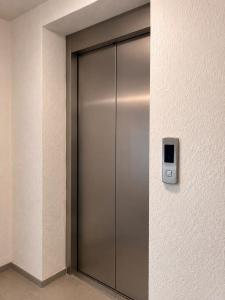 a metal elevator door in a building at Hotel Kopala Ureki in Ureki