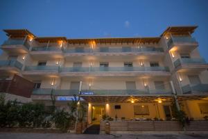 a large white building with lights on it at Grand Boutique in Vasiliki
